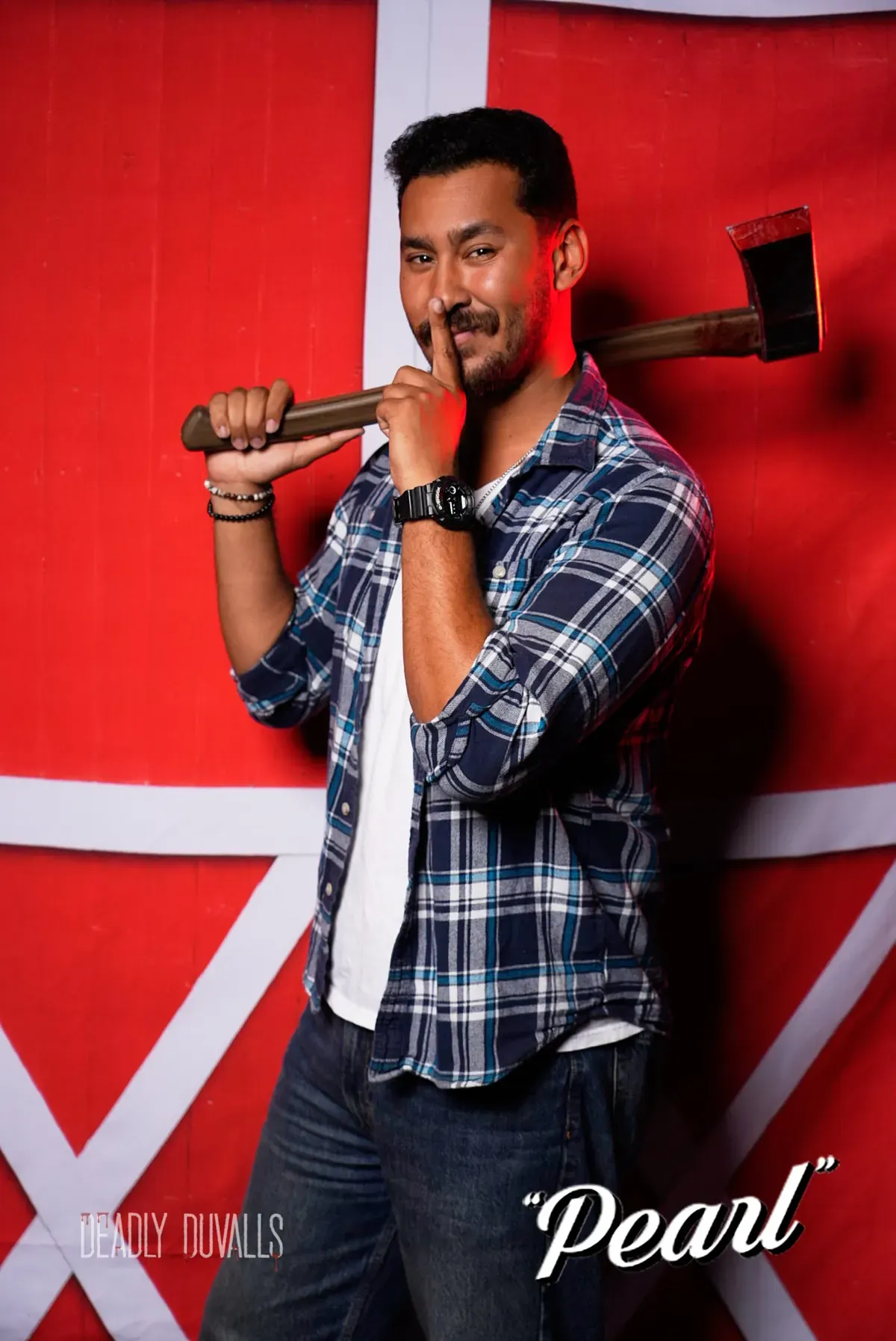 Guest in a plaid shirt resting a prop axe on his shoulder with a finger to his lips, Pearl photo booth portrait by Deadly Duvalls