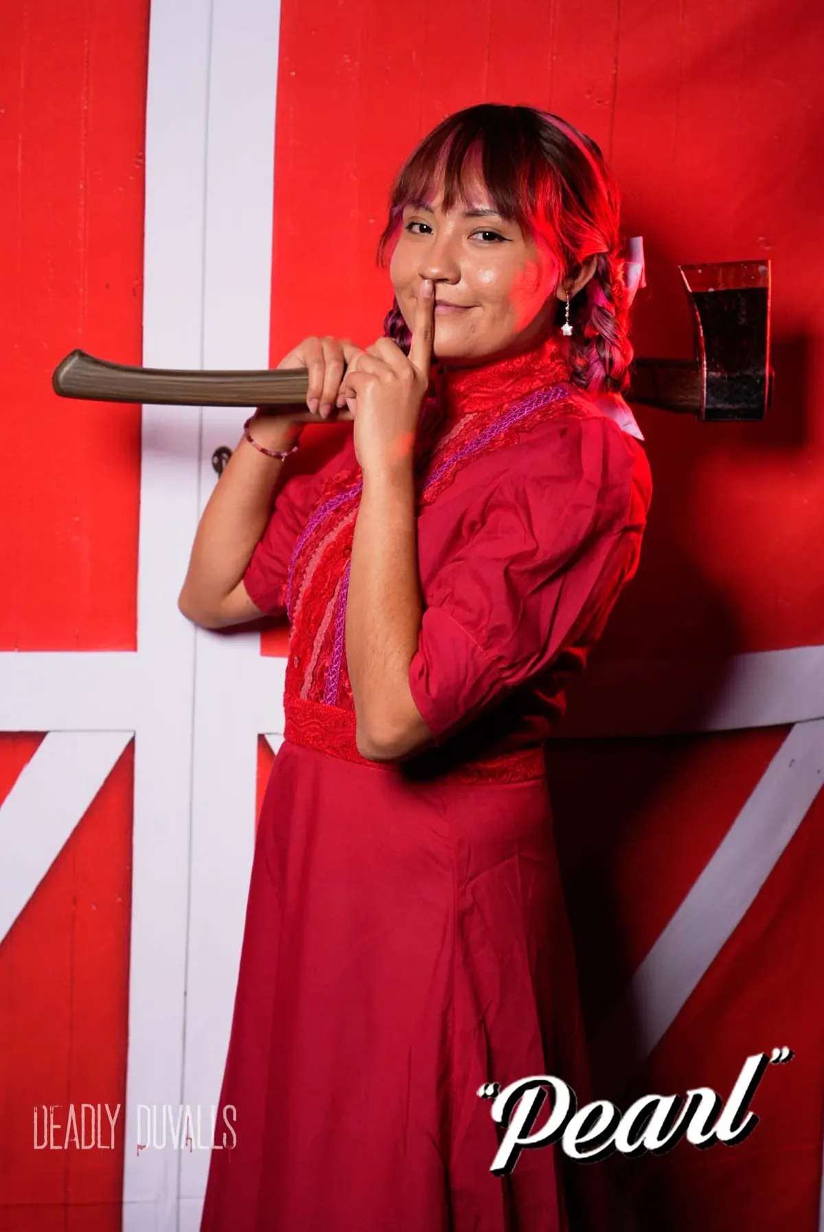 Guest in a red prairie dress with braided hair holding an axe and a finger to her lips, Pearl photo booth portrait by Deadly Duvalls